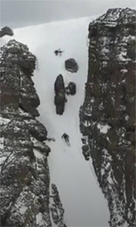 Skiing down the center of two cliffs.