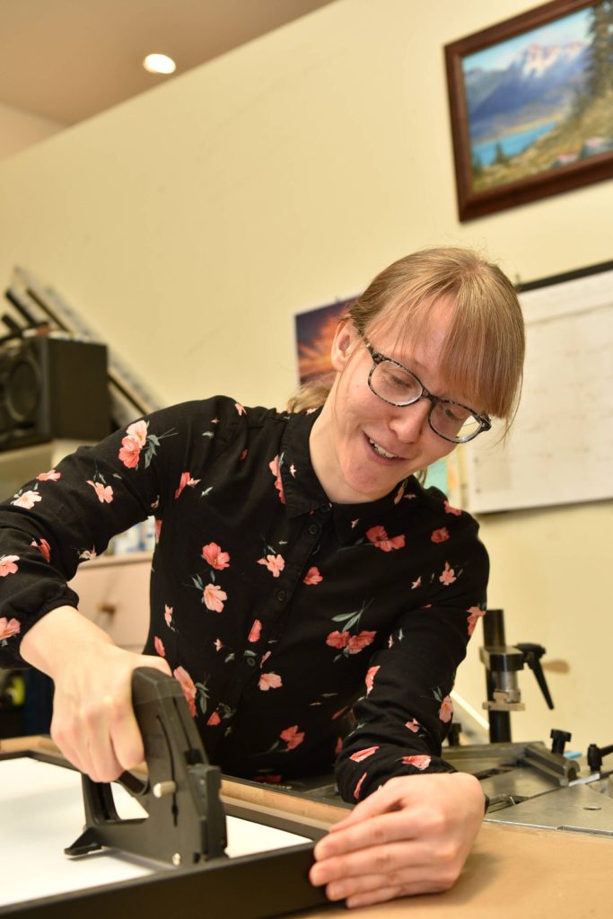 Crista Dougherty works on a frame at Julie's Frame Gallery.