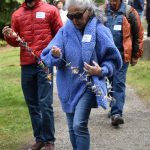 Visitors carry strings of paper cranes to place along the Japanese Exclusion Memorial wall.