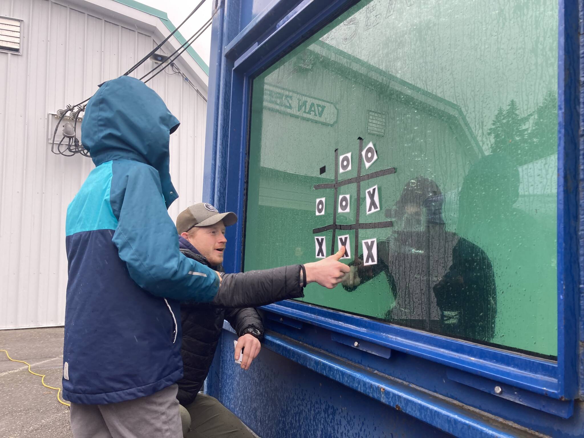 A student partakes in a game of tic-tac-toe with an underwater diver.