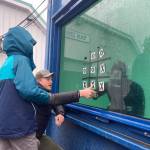 A student partakes in a game of tic-tac-toe with an underwater diver.