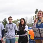 Sophomores Theo Oestreich, Maia Greiwe and Mae Wysong look on as Alexandra Velisaris speaks to attendees before the walk began.