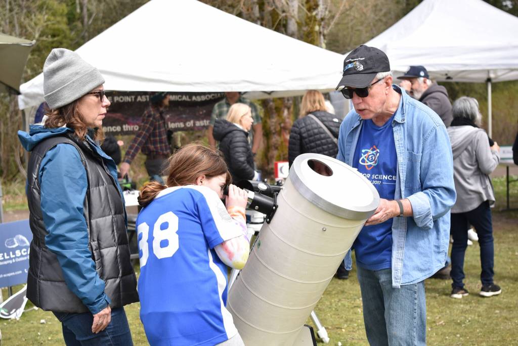 Erika Dorsey and daughter Quinlynn learn about a Meade telescope from Battle Point Astronomical Association volunteer Joe Mulligan.