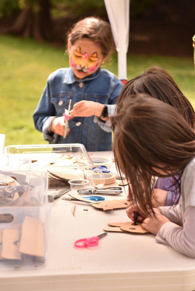 Anika Bhatt makes art from recycled materials with other children at the KiDiMu booth on Earth Day.