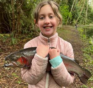 Avery Britt, 9, of Bainbridge Island shows off a fish she caught then released at the BI Sportsmen's Club annual Huck Finn and Becky Thatcher Kids' Fishing Derby. Daniel Britt courtesy photo