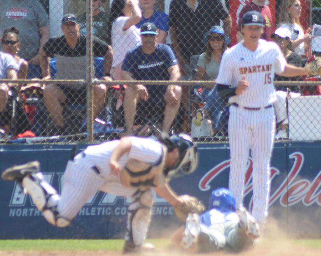 Catcher JT Hardy tags the runner, while Spartan pitcher Cole Pentin backs him up and thinks they got the runner. But the umpire called him safe.