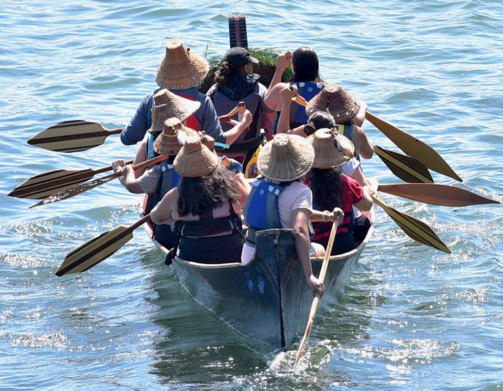 A canoe proceeds to the beach to come ashore on the Suquamish reservation.