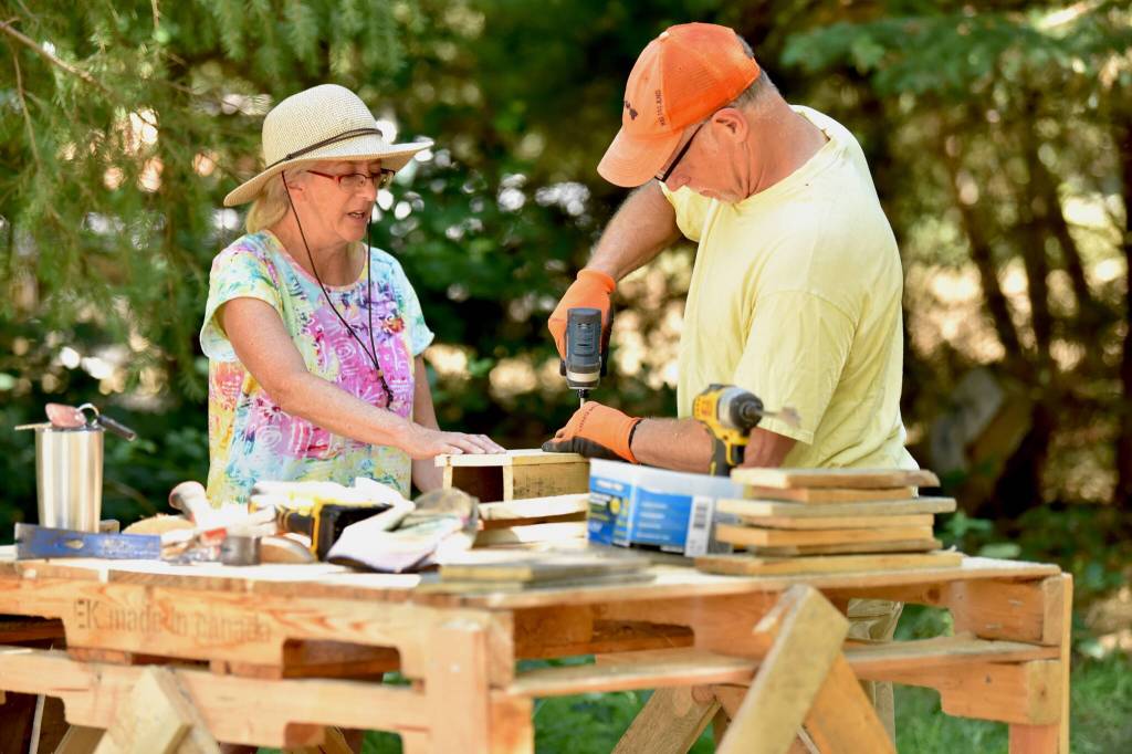 Island volunteers Julie Bennett and Steve Keller make birdhouses for the art installation at Sakai Park.