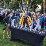 Community members light candles during the prayer and unity rally at Waterfront Park on Oct. 12.