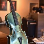 A green violin with Orca features on display in the studio is one of several items made by local artists.