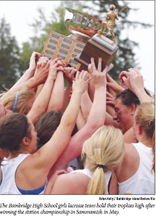BHS girls celebrate state championship in lacrosse with their coach.