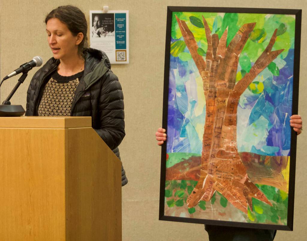 Odyssey School parent Claire Richards presents a collaborative Odyssey student art piece at the meeting.