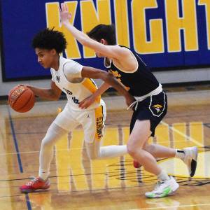 Nicholas Zeller-Singh/Kitsap News Group
Knight Aaron Matthews dribbles past Spartan Teddy Hanlon.