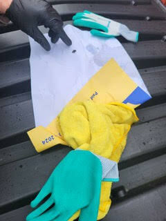 A gardening glove and a yellow rag wrapped in a piece of paper with political advertising adjacent to the Sons of Norway parking lot on Jan. 26.