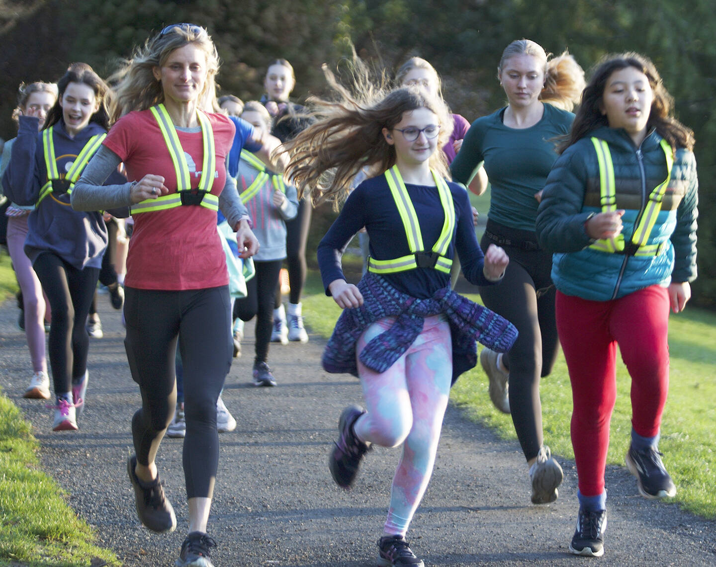 Ann Browning, left, coach and co-director of Go Run Bainbridge, jogs with Emersen Ewing, Frankie ONell and her team of girls at a practice.