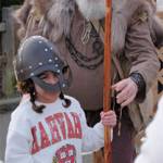 A Viking helps a young participant safely handle a spear during Viking Fest Feb. 10.