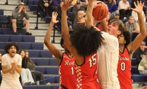 Sophomore Logan Hudson goes up with the ball while surrounded by Redhawks players.