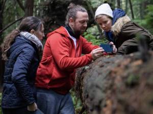 Washington Filmworks courtesy photo
Ingress director Rachel Noll James, left, cinematographer Dan Clarke and co-producer Sienna Beckman lean on a log behind the scenes of the film.