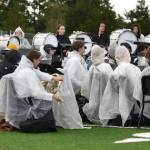 The band adorns ponchos to prepare to perform in the rain.