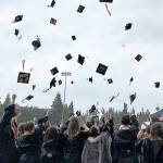 Bainbridge High School graduates toss their caps into the air to celebrate the end of the ceremony.