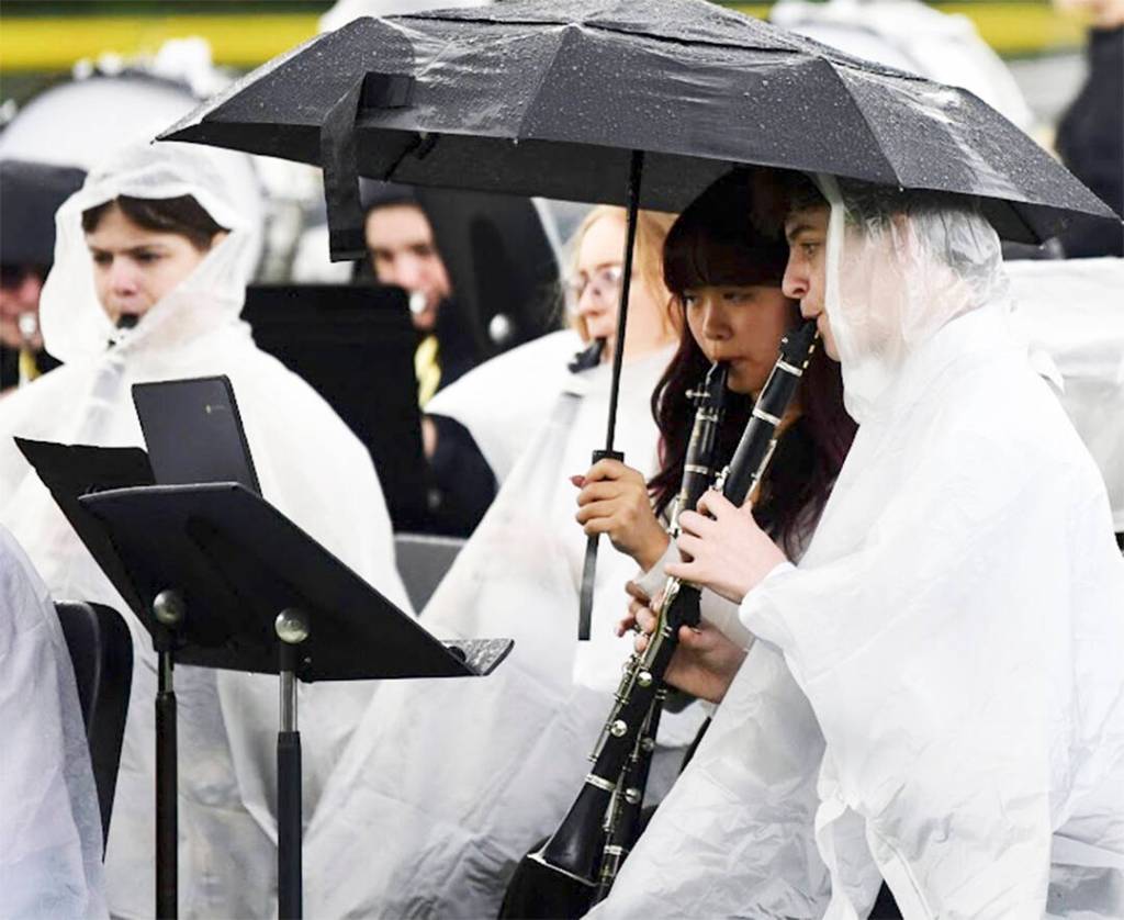 Members of the band were able to keep somewhat dry by wearing raincoats, and some even were able to take cover under an umbrella.