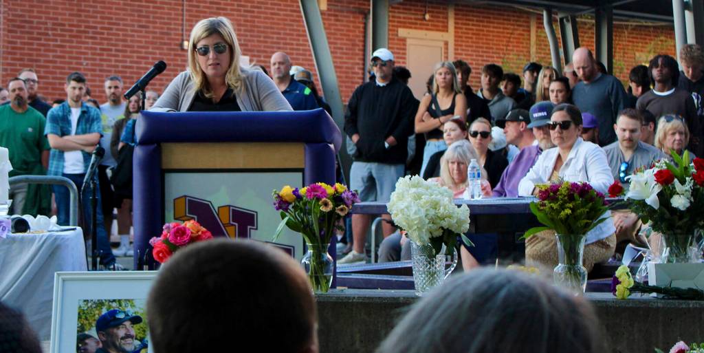 Joanna Pruden offers some opening remarks before a large crowd mourning the loss of Dave Snyder.