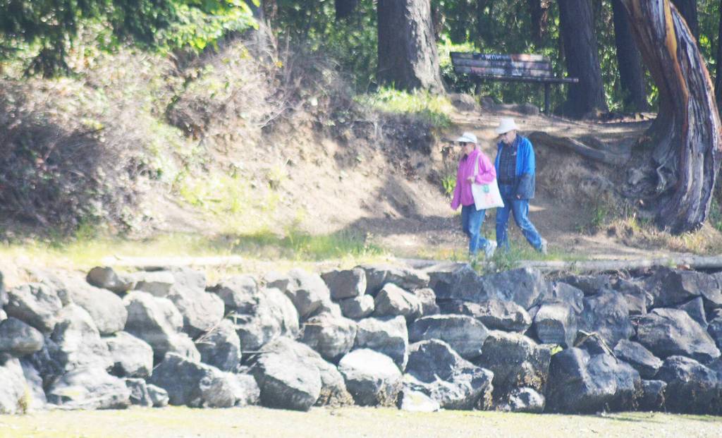 A couple walk along the waterfront trail recently on Eagle Harbor.