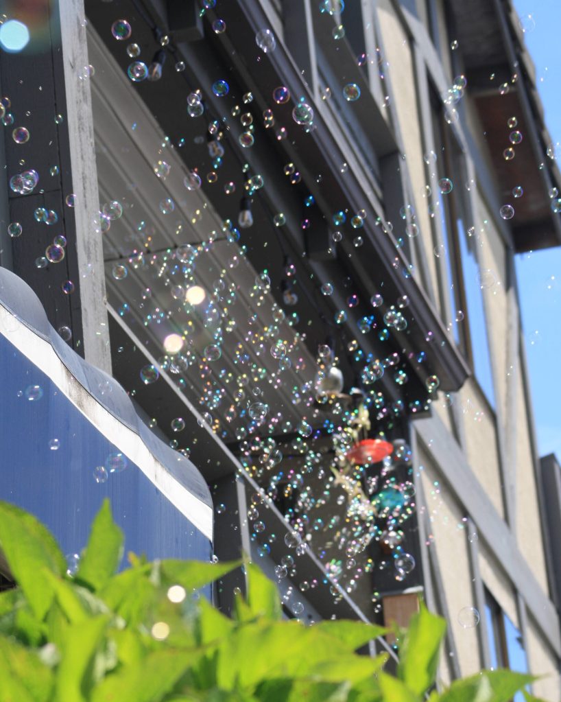 Organizer Gerald Simonsen set up a bubble machine on his apartment balcony, overlooking the Winslow Green.