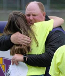 Damon Williams/Kitsap News Group photos
Head North Kitsap High School football coach Jeff Weible gets a hug at the memorial for one of his assistant coaches, Dave Snyder, who died recently while the team was at a camp in Ellensburg.