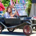 A mini Model T helps lead the way in this year's parade. Otto, in front, had plenty of fun in the passenger seat.