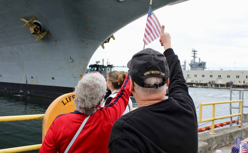 Ann and Scott Case give a thumbs up to their son after spotting him aboard the USS Ronald Reagan.