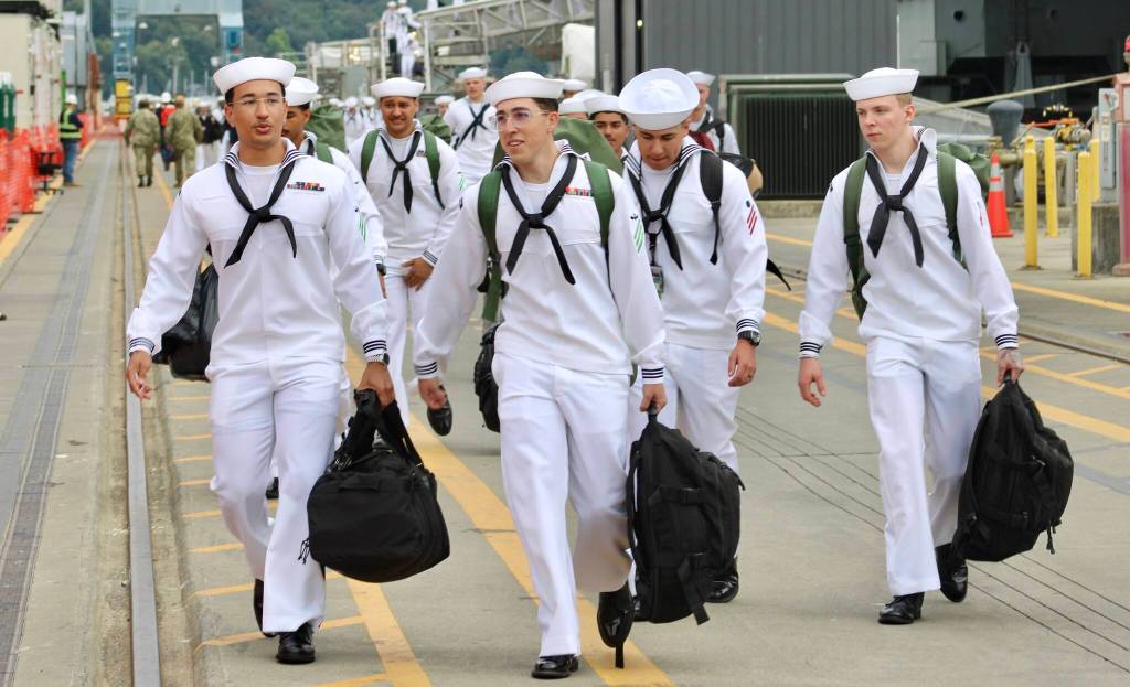Sailors file off the USS Ronald Reagan and walk to their new home of Kitsap County.