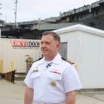 Commanding officer Capt. Daryle Cardone answers questions from the media with the USS Ronald Reagan behind him.