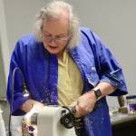 Sawdust goes flying as Robyn Weimer works on a piece of wood in the lathe.