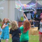 Deanna Riley entertains a group of kids with her bubble making.