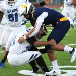 Spartan quarterback Jack Grant braces himself for the hit as he races for a first down against the Olympic Trojans.
