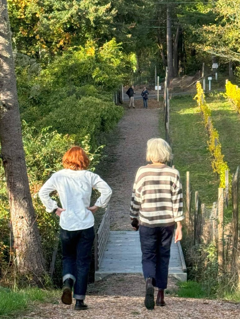 Two city employees follow the trail as it slopes toward Day Road E.