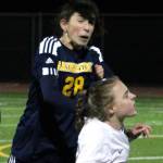 Spartan junior Taylor Mass goes up for a header against Ellie Stanford of NK.