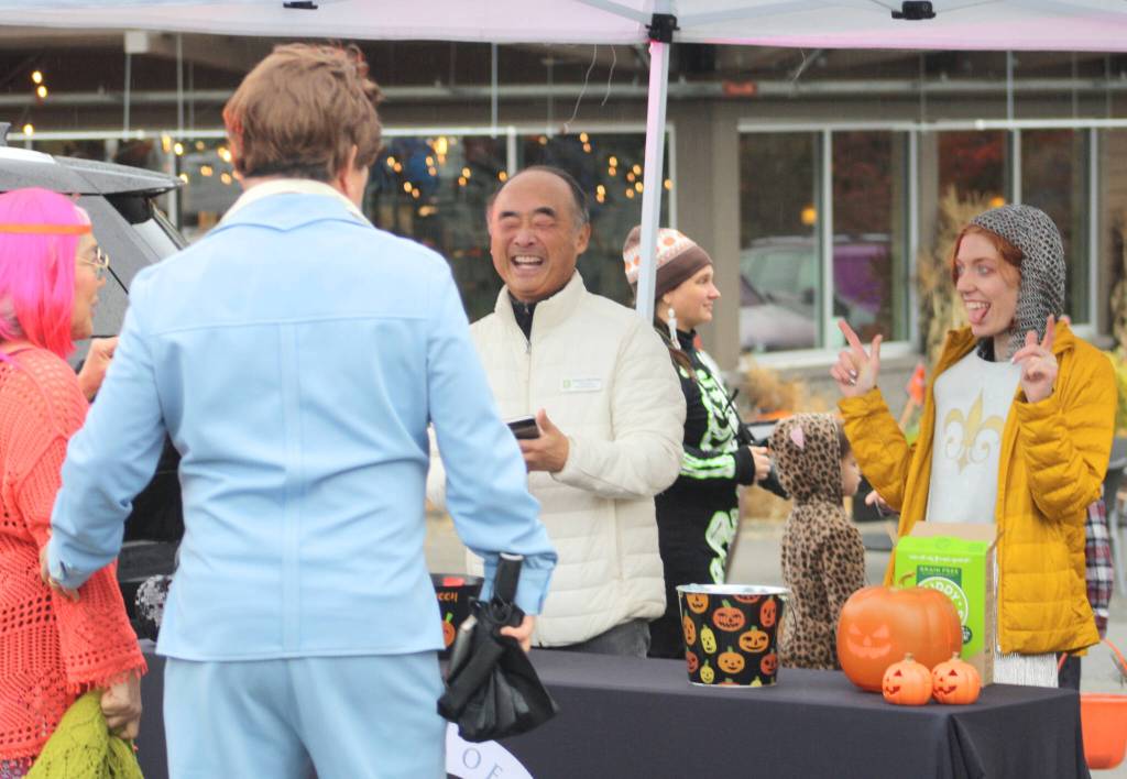 Bainbridge Island City Councilmember Clarence Moriwaki and a city employee laugh with festival attendees.