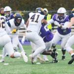 Sophomore Zach Ausmeier (41) tackles Shia Webster of Anacortes while Carson Williams (32) and Wyndham Kochenash (51) move in to help.