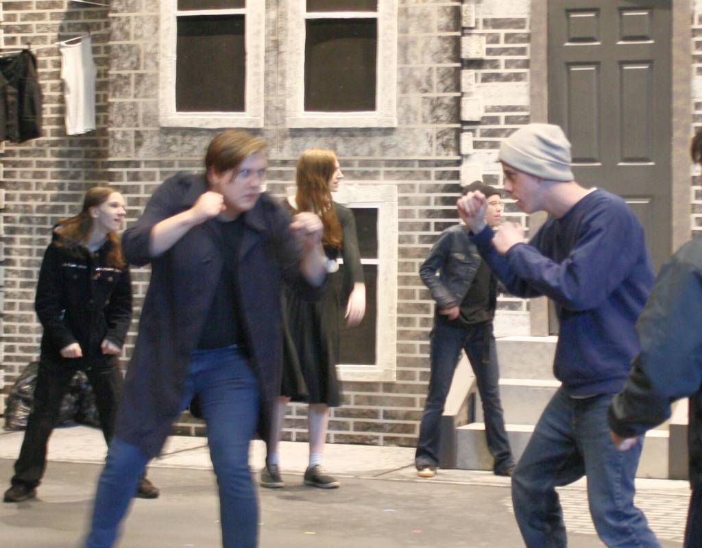 Greaser Darry (Liam Hayes, left) and soc Paul (Luke Rowe) duke it out during a rumble.