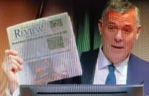 Steve Powell/Kitsap News Group
Bainbridge Mayor Joe Deets holds up the Review showing the top story is about the Highway 305-High School Road roundabout.
