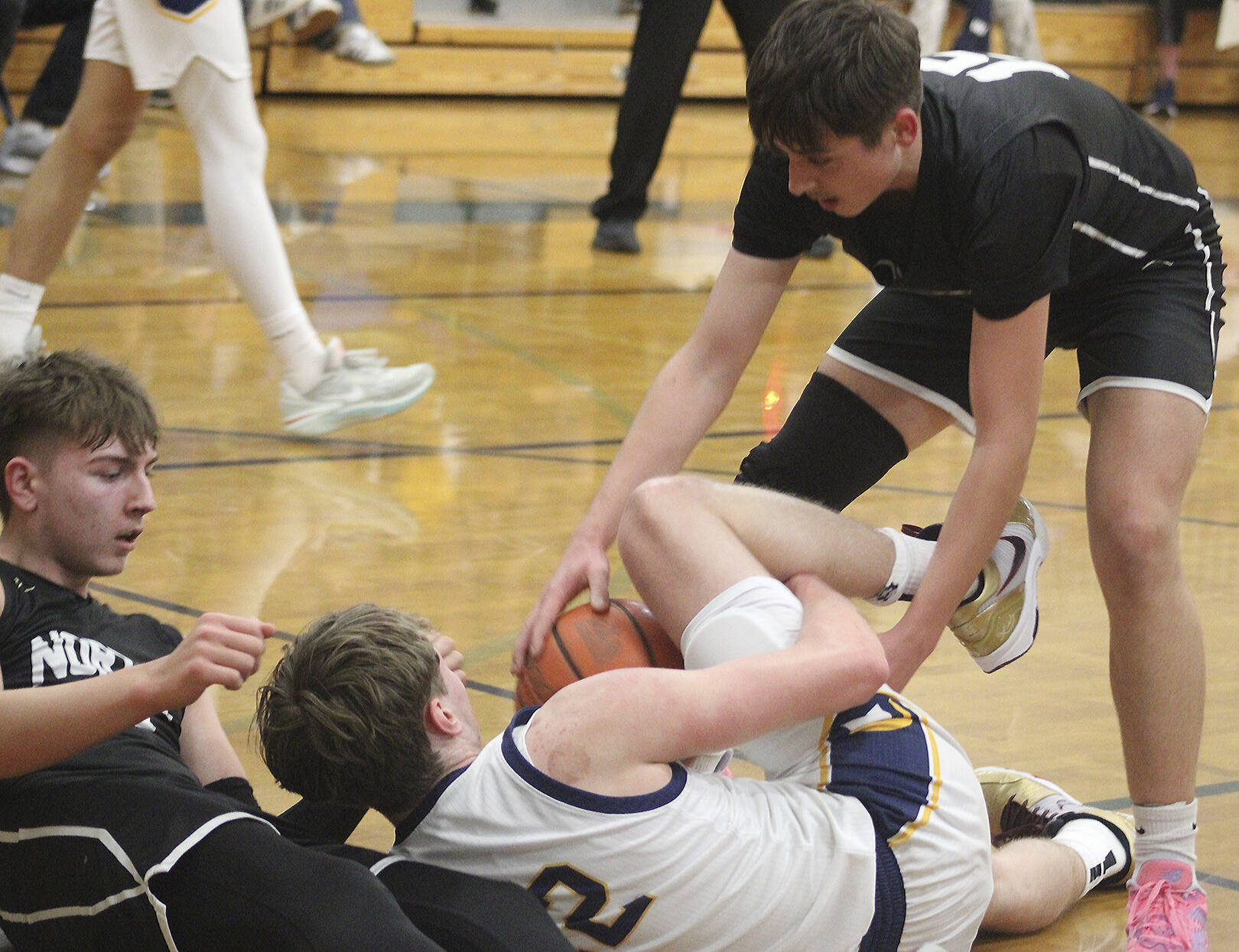 North Kitsap junior Justin Weigand competes for a jump ball with Bainbridge senior Luke Johnson in a 55-52 Spartan win at Bainbridge High School Feb. 11.