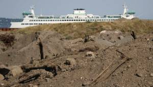 File photo
A few large piles of creosote-contaminated dirt frame the future view from Pritchard Park, while a ferry arrives in Bainbridge.