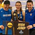 Allie Wildsmith accepts her national championship plaque surrounded by track coach Ethan Brown, left, and jumps coach John Jaskot.