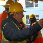 City manager Blair King asks LIHI construction crew members about their work on breezeways and structure siding.