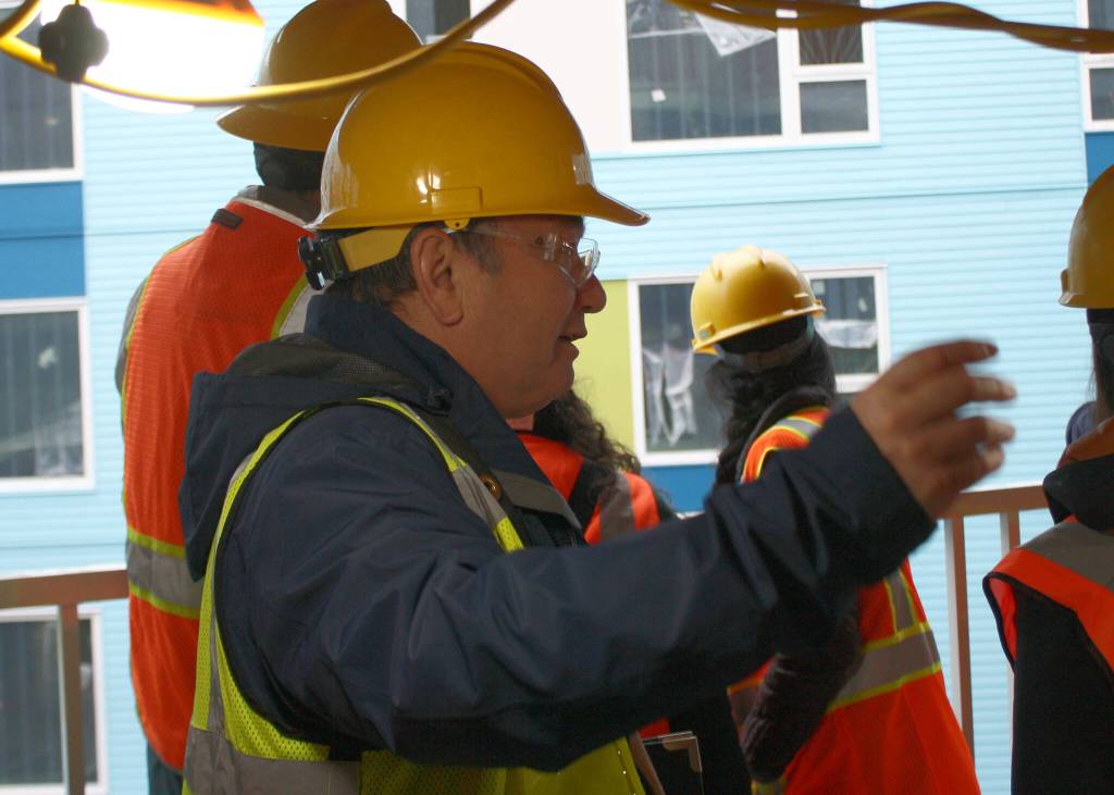 City manager Blair King asks LIHI construction crew members about their work on breezeways and structure siding.