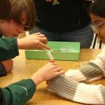 Students Alexander St. Cyr and Sonali Siddaiah work to assemble the filtration system.
