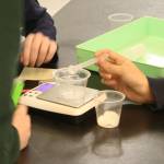 Students measure a tiny amount of microscopic glass beads in preparation for the filtration experiment.
