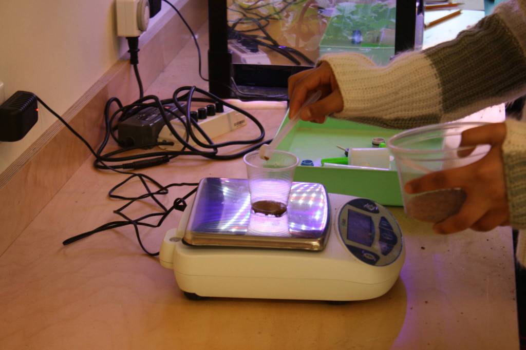 Students measure arcillite to use in a filtration experiment.